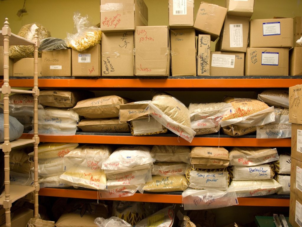 Interior de un trastero temporal organizado con cajas apiladas y un mueble